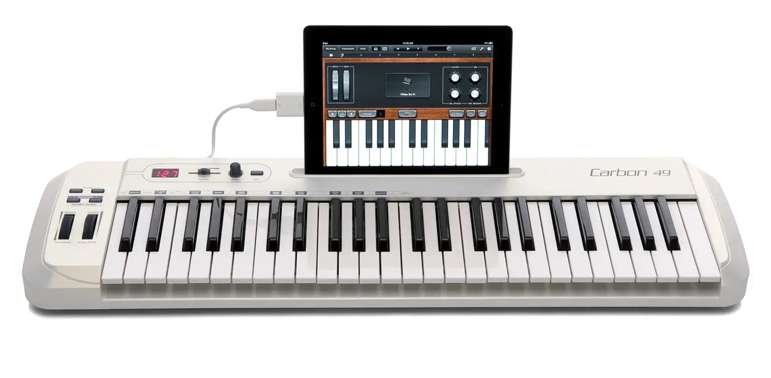 Samson Carbon 49 MIDI controller connected to laptop and iPad in a home studio setup.