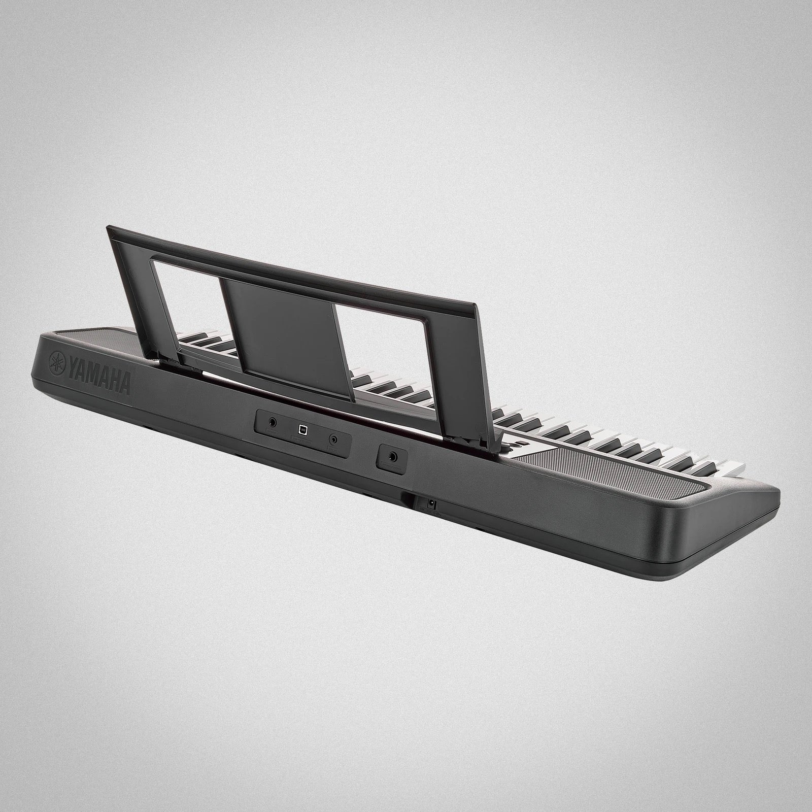 Yamaha keyboard e383 on a gray background
