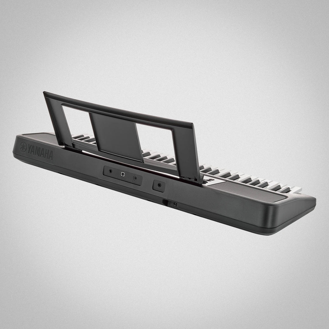 Yamaha keyboard e383 on a gray background